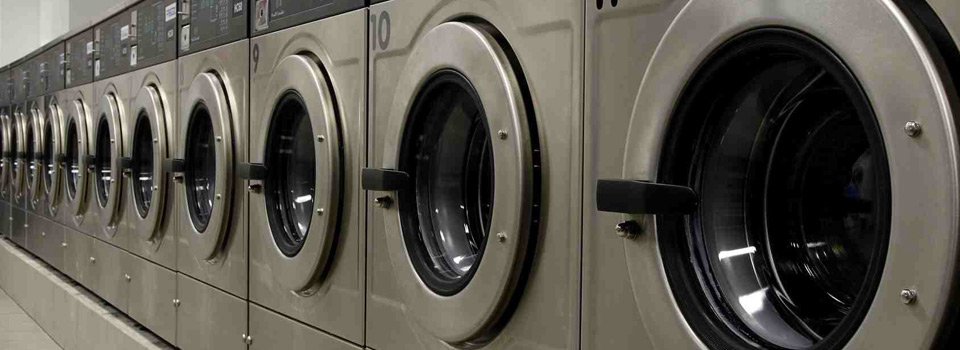Row of industrial washing machines at Majestic Laundrette